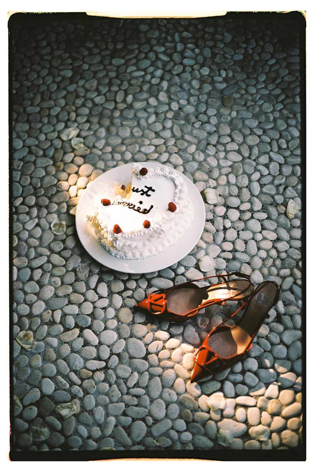 Film photo of wedding cake and brides red shoes