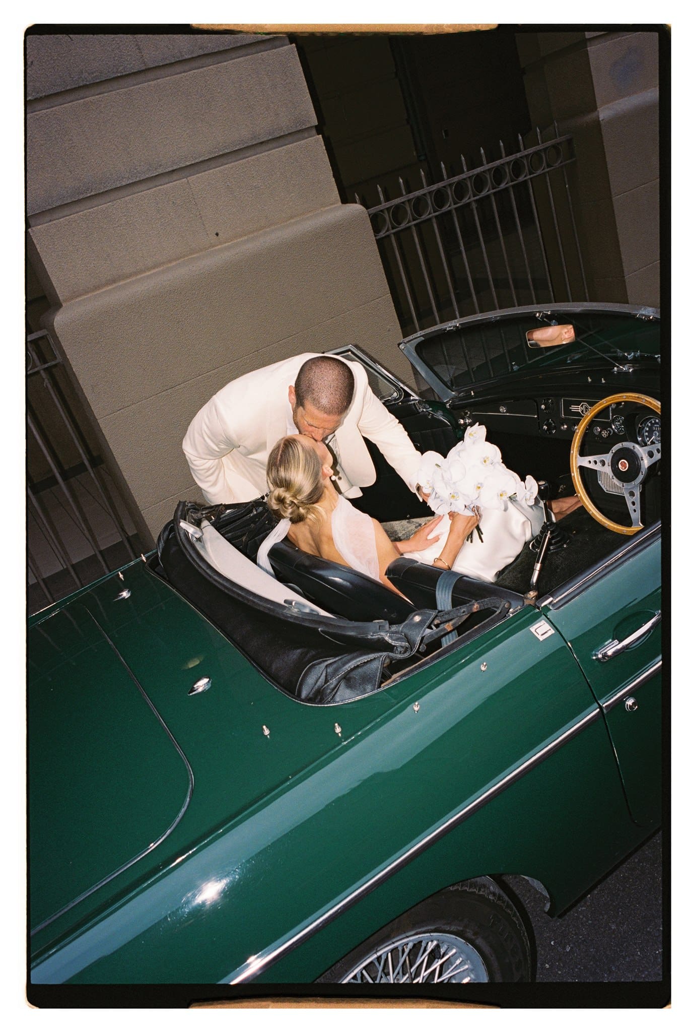 Film photo of bride and groom and their wedding car in Adelaide